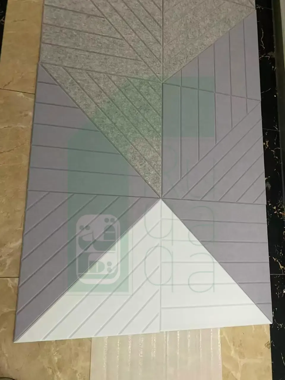 Ruqaqa acoustic felt panels in grey, lilac and white forming a geometric triangular pattern with grooved diagonal lines
