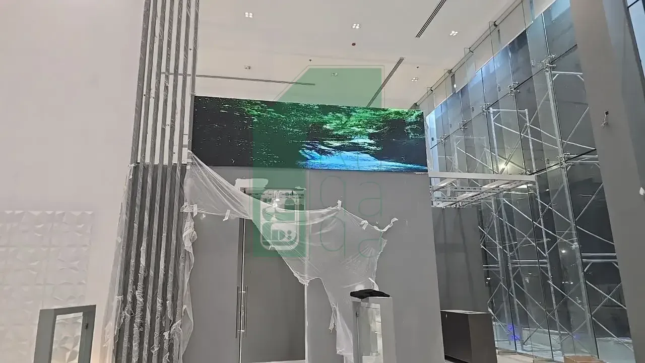 Ruqaqa wide indoor flat LED screen in a building lobby displaying an ultra-sharp nature scene