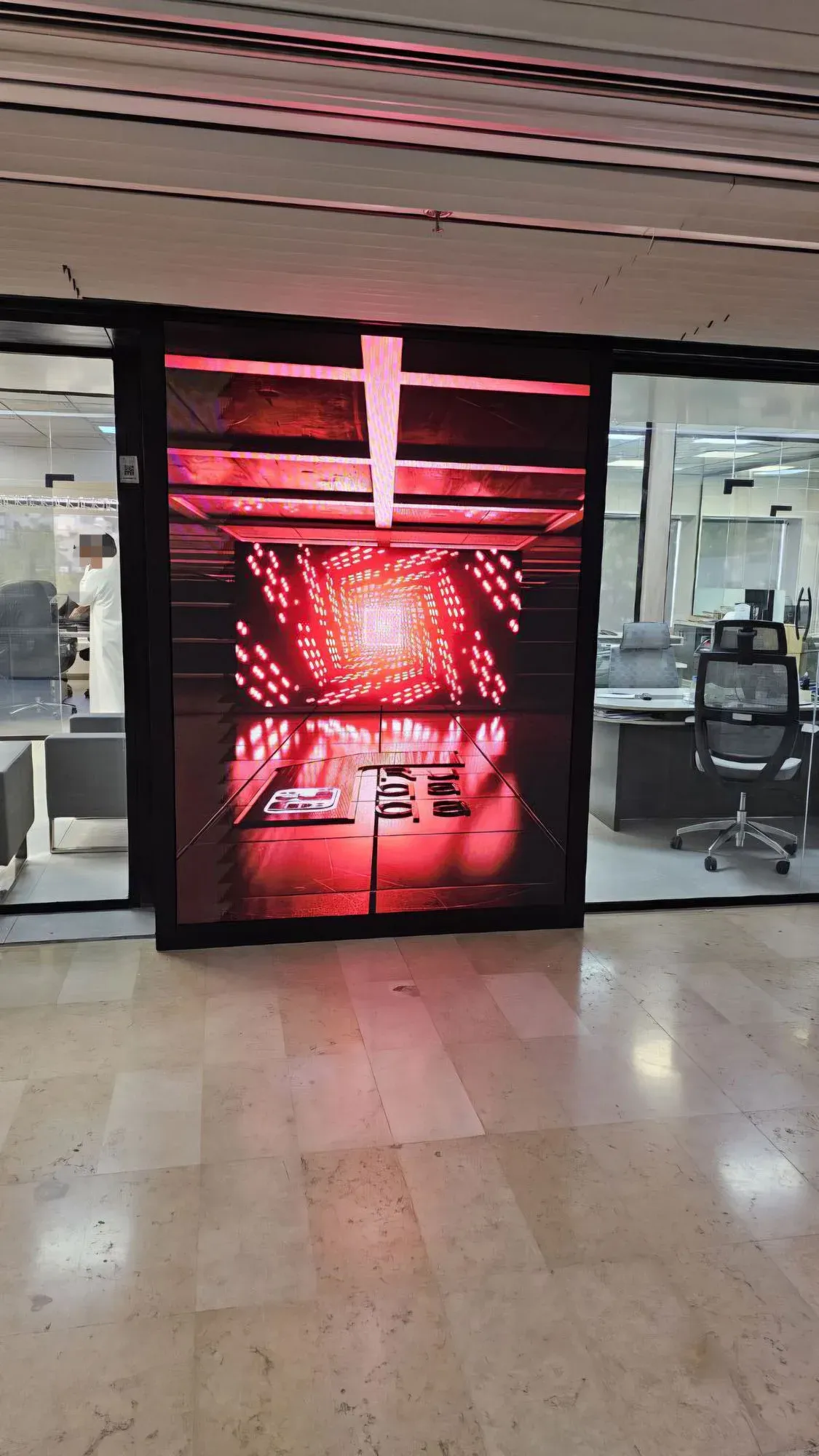 Vertical Ruqaqa flat LED screen in an office displaying 3D red-tunnel content